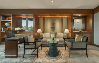 a living room with a couch and chairs at Conrad Bangkok in Bangkok