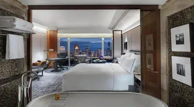 a hotel room with a bed and a bath tub at Conrad Bangkok in Bangkok