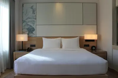 a bedroom with a large white bed and two lamps at Courtyard by Marriott Bangkok in Bangkok