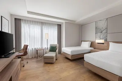 a hotel room with a bed and a tv at Courtyard by Marriott Bangkok in Bangkok