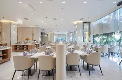 a dining room with white tables and chairs at The Four Wings Hotel Bangkok in Bangkok