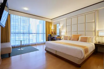 a bedroom with a large bed and a large window at The Four Wings Hotel Bangkok in Bangkok