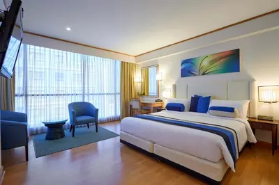 a hotel room with a large bed and a desk at The Four Wings Hotel Bangkok in Bangkok