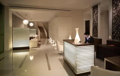 a woman sitting at a table in a lobby at NH Bangkok Asoke in Bangkok