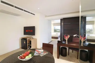 a living room with a table with a bowl of fruit at The Quarter Saladaeng by UHG in Bangkok
