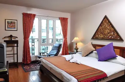 a bedroom with a bed and a large window at The Siam Heritage Hotel in Bangkok