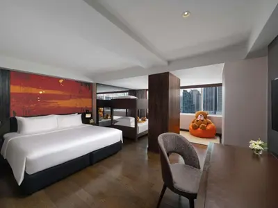 a hotel room with a bed and a desk and a table at Mercure Bangkok Sukhumvit 11 in Bangkok