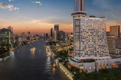 a tall building next to a river in a city at Millennium Hilton Bangkok in Bangkok
