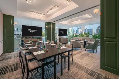 a restaurant with tables and chairs and a view of the city at Millennium Hilton Bangkok in Bangkok