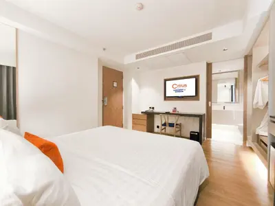 a bedroom with a white bed and a tv at Citrus Sukhumvit 13 Nana Bangkok by Compass Hospitality - Newly Renovated in Bangkok