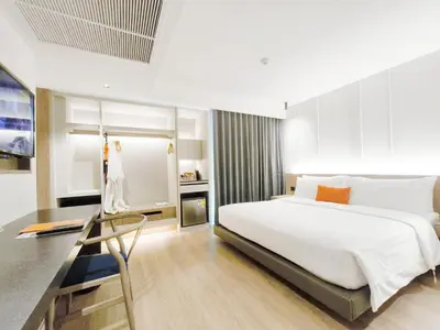 a bedroom with a white bed and a glass table at Citrus Sukhumvit 13 Nana Bangkok by Compass Hospitality - Newly Renovated in Bangkok