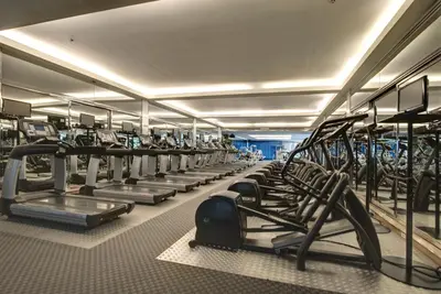 a large gym with rows of tread machines at Pathumwan Princess Hotel in Bangkok
