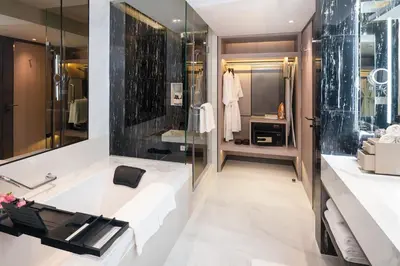 a bathroom with a large tub and a sink at Pathumwan Princess Hotel in Bangkok