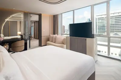 a hotel room with a bed and a flat screen tv at Pathumwan Princess Hotel in Bangkok