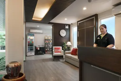 a woman standing behind a counter in a room at iCheck inn Residence soi 2 in Bangkok