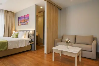 a bedroom with a bed and a couch and a table at iCheck inn Residence soi 2 in Bangkok