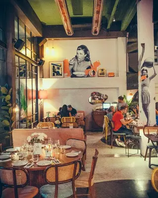 a restaurant with people sitting at tables in a room at Sacha's Hotel Uno in Bangkok
