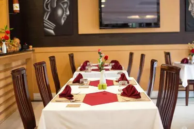 a table with a white table cloth and red napkins at Metro Point Bangkok in Bangkok
