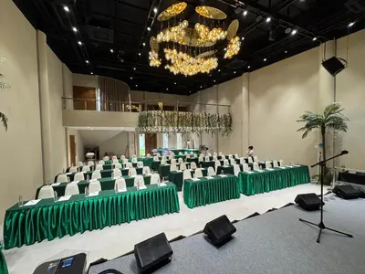 a banquet hall with green and white chairs and a chandelier at Metro Point Bangkok in Bangkok