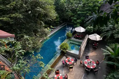 an overhead view of a swimming pool with tables and umbrellas at Ariyasom Villa in Bangkok