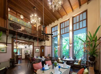 a restaurant with tables and chairs and chandeliers at Ariyasom Villa in Bangkok