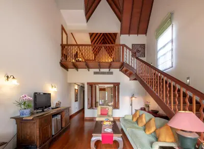 a living room with a staircase and a couch at Ariyasom Villa in Bangkok