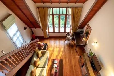 a living room with a couch and a large window at Ariyasom Villa in Bangkok