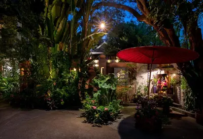 a red umbrella in a garden at night at Ariyasom Villa in Bangkok