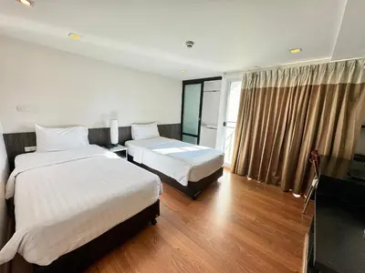 a hotel room with two beds and a window at I Residence Hotel Sathorn in Bangkok