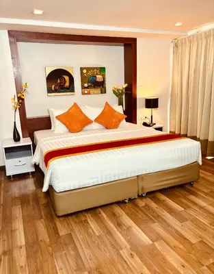 a bedroom with a large bed with orange pillows at I Residence Hotel Sathorn in Bangkok