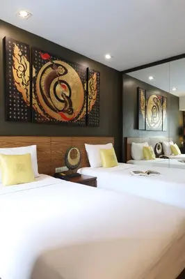 a hotel room with two beds and a mirror at Sleep Withinn in Bangkok