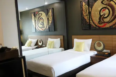 three beds in a room with paintings on the wall at Sleep Withinn in Bangkok