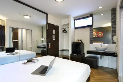 a hotel room with two beds and a television at Sleep Withinn in Bangkok