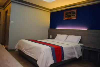 a bedroom with a large bed with a blue wall at Bangkok Loft at Nana Station in Bangkok