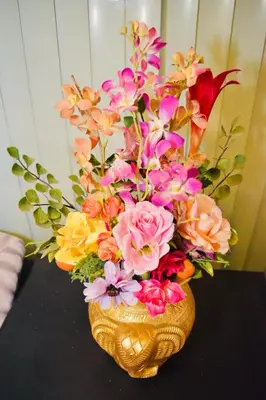 a vase filled with flowers on a table at Bangkok Loft at Nana Station in Bangkok