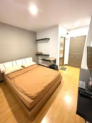 a bedroom with a bed and a desk and a door at Inn Trog And Inn Soi in Bangkok