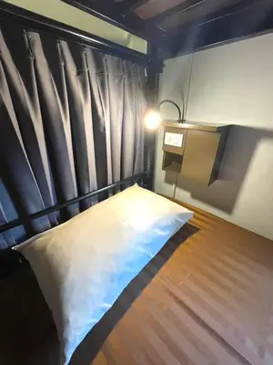 a bed with a black headboard in a room at Inn Trog And Inn Soi in Bangkok