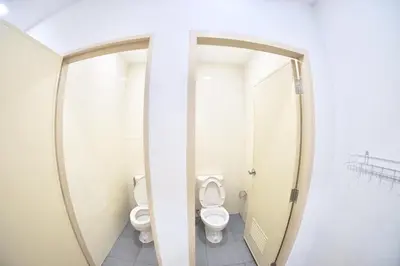 a bathroom with two toilets and a mirror at Inn Trog And Inn Soi in Bangkok