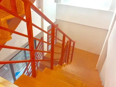 a staircase with orange railings in a building at Inn Trog And Inn Soi in Bangkok