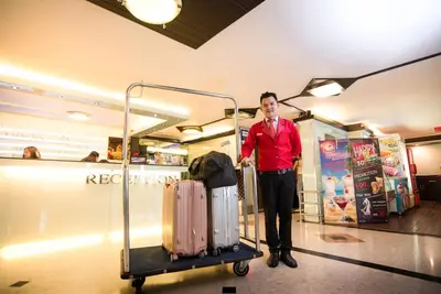 a man standing next to a luggage cart in a store at Vabua Asotel Bangkok in Bangkok