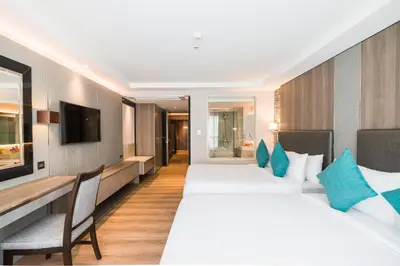 a hotel room with two beds and a television at Citrus Suites Sukhumvit 6 by Compass Hospitality in Bangkok
