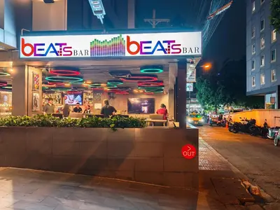 a restaurant on a street at night with neon signs at Citrus Suites Sukhumvit 6 by Compass Hospitality in Bangkok