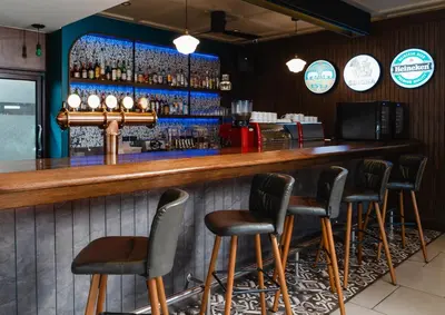 a bar with five stools in a restaurant at The Dawin Hotel in Bangkok