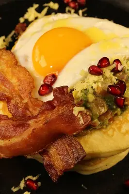 a fried egg on top of a bagel with bacon at The Dawin Hotel in Bangkok
