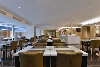 a restaurant with tables and chairs and a bar at Le D'Tel Bangkok in Bangkok