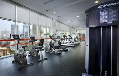 a gym with a row of treadmills and machines at Lohas Residences Sukhumvit 2 in Bangkok