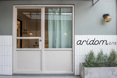 a white door on a white building with a window at Aridom Designer Loft House in Bangkok