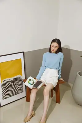 a woman sitting on a chair reading a book at Aridom Designer Loft House in Bangkok