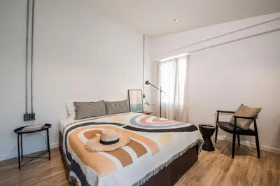 a bedroom with a bed and a table and a chair at Aridom Designer Loft House in Bangkok