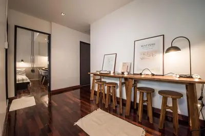 a room with a wooden bar with stools at Aridom Designer Loft House in Bangkok